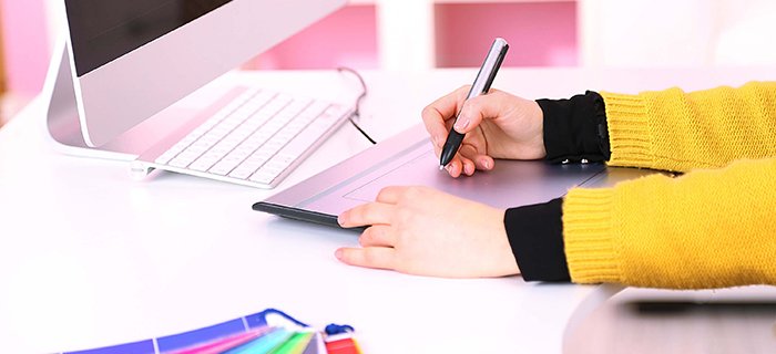 Young woman graphic designer working using pen tablet in workplace